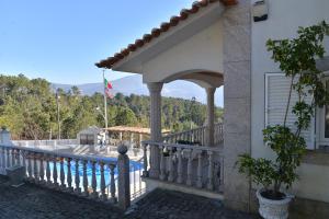 a balcony of a house with a flag on it at Casa Estrela de Alva in Seia