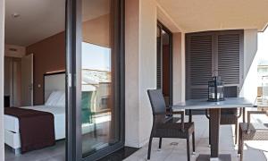 un balcone con un letto, un tavolo e delle sedie di Residence Ormeggio a Grado