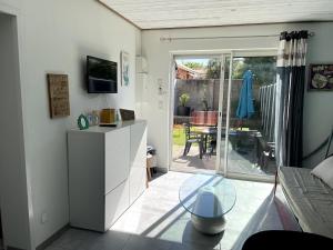 a living room with a table and a sliding glass door at Maison une chambre avec jardin in Les Sables-d'Olonne