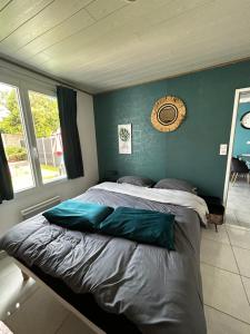 a bedroom with a large bed with a blue wall at Maison une chambre avec jardin in Les Sables-d'Olonne