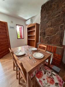 a wooden table in a room with a stone wall at Casa rural en La Adrada con jardín in La Adrada