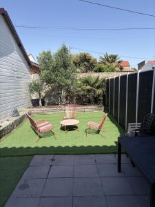 two chairs and a table on a lawn at Maison une chambre avec jardin in Les Sables-d'Olonne