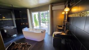 a large bathroom with a tub and a window at Villa Petra Bianca Suites & Chambres in Bonifacio +58 photos
