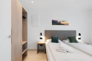 a bedroom with two beds and a night stand with a desk at Bike Apartments Curti - Waldgrün in Laives