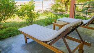 a chair and a table on a porch with the beach at Ampasoa Beach in Nosy Be +39 photos