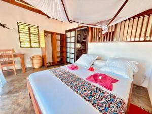 a bedroom with a bed with pink flowers on it at Ampasoa Beach in Nosy Be