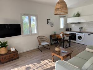 a living room with a couch and a table at Le Rossignol 3, Aiguebelle plage, Le Lavandou in Le Lavandou