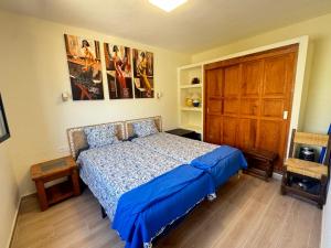 a bedroom with a blue bed and a wooden door at Casa Solano in Tías