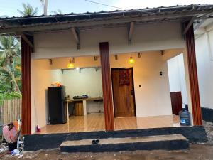 a house with a kitchen and a door in it at KUTA GLORI Homestay in Kuta Lombok