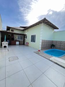 a house with a patio and a swimming pool at Casa com Piscina Privativa e Área Gourmet in Rio das Ostras