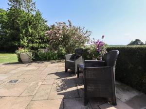 two chairs and a table with flowers on a patio at Ivy House in Louth
