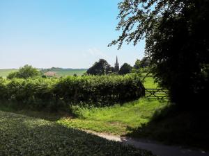 a field of grass with a fence and a tree at Ivy House in Louth +2 photos