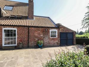 a brick house with a blue garage at Ivy House in Louth