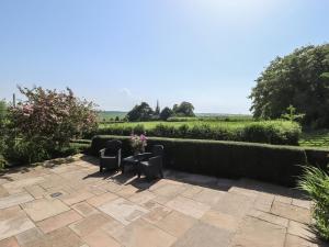 a patio with two chairs and a table with flowers at Ivy House in Louth