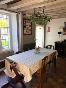 a dining room table with a checkered table cloth on it at A l'orée de la forêt in Recloses +16 photos