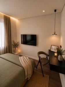 a bedroom with a bed and a desk and a television at Luxury apartment in Vilnius +1 photo