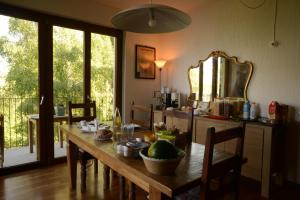 a kitchen with a wooden table with chairs and a large mirror at il larice d' oro in Sueglio
