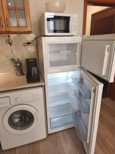 a kitchen with a microwave and an open refrigerator at Apartment in the Center 2 in Varna City