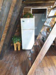 a refrigerator in the middle of a room with wooden floors at Cabaña Capitán Viruta in Rosario