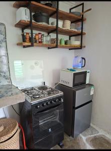 a kitchen with a stove and a microwave at The Nook,Kilifi in Kilifi