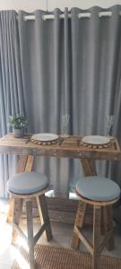 a wooden table with two stools and plates on it at 2 on Fifth Avenue in Botrivier