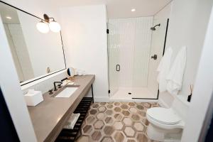 a bathroom with a toilet sink and a shower at Hotel Covington Cincinnati Riverfront in Covington