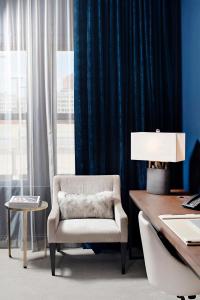 a office with a chair and a desk with a lamp at Hotel Covington Cincinnati Riverfront in Covington