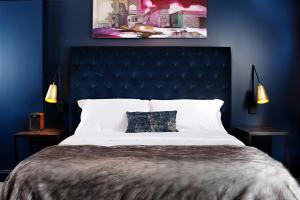a bedroom with a large bed with a blue wall at Hotel Covington Cincinnati Riverfront in Covington