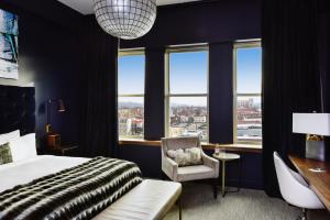 a bedroom with a bed and a chair and windows at Hotel Covington Cincinnati Riverfront in Covington +34 photos