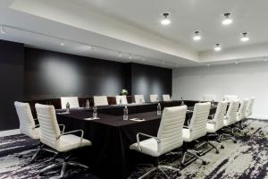 a conference room with a long table and white chairs at Hotel Covington Cincinnati Riverfront in Covington