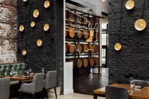 a restaurant with tables and chairs and a wall with wine barrels at Hotel Covington Cincinnati Riverfront in Covington