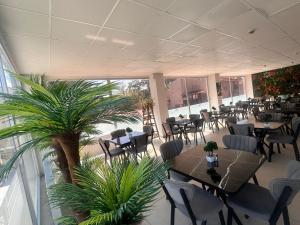 a restaurant with tables and chairs and a palm tree at Avka Palace in Edirne