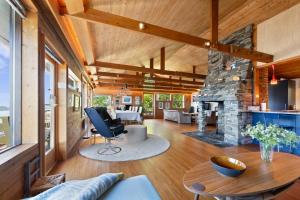 a living room with a stone fireplace and a table at Skyline View - Nordic Villa Above Bergen in Bergen