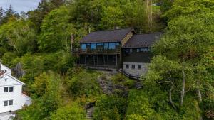 a house on the side of a hill with trees at Skyline View - Nordic Villa Above Bergen in Bergen