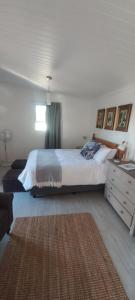 a bedroom with a large bed and a window at 2 on Fifth Avenue in Botrivier