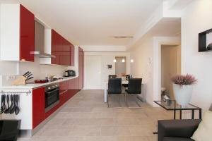 a kitchen and living room with red cabinets and a table at Casa Laura Apt 3 in Menaggio