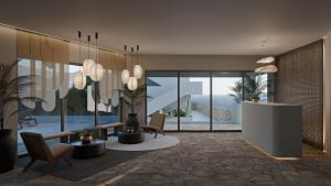 a living room with chairs and a table and a room with windows at Grecale Filoxenia in Vrachonisída touArchangélou