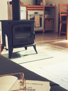 a stove in a living room with glasses on the floor at Nowy dom przy starym krześle - w Pelniku in Pelnik +11 photos