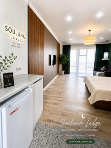 a living room with a bed and a kitchen at Souluna lodge in Chyrpykty