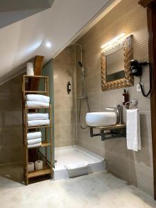a bathroom with a sink and a shower with towels at Nikolas Haus Premium Historic Center Stay & Free Parking in Braşov +58 photos