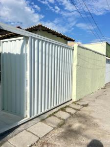 a white fence in front of a house at Casa com Piscina Privativa e Área Gourmet in Rio das Ostras