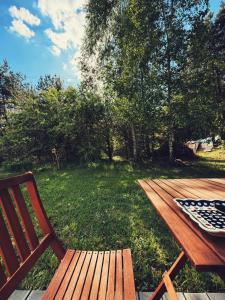 a wooden picnic table and a bench in a yard at Nowy dom przy starym krześle - w Pelniku in Pelnik