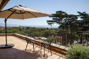 a patio with an umbrella and a table and chairs at Best Western Plus Hotel Globus in Rome