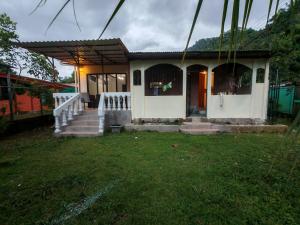 a small house with a porch and a grass yard at Casa Congo in Golfito