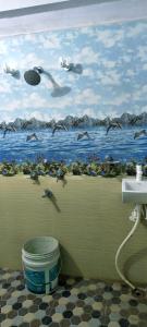 a bathroom with a painting of birds flying over the ocean at Om Siya Ram Resort in Rājgīr