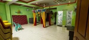 a room with green walls with curtains and a blue chair at Om Siya Ram Resort in Rājgīr