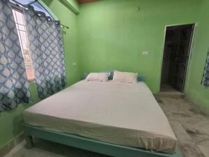 a bedroom with a bed in a green room at Om Siya Ram Resort in Rājgīr