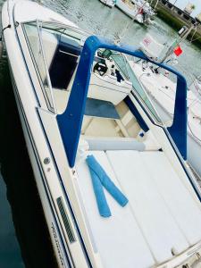 a white boat with a blue door in the water at VINA ROMANCE - Romantic Boat Stay in Lisbon Marina in Lisbon