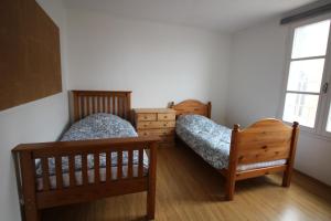a bedroom with two beds and a window at La Chandeler in Juvigny-sous-Andaine
