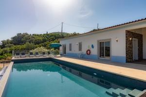 a swimming pool in front of a house at Villa Belchior by Algarve Holidays in Faro